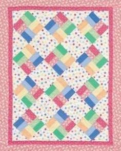 a pink and green quilt with polka dots on the border, in front of a white background