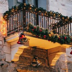 a balcony decorated for christmas with lights and bells