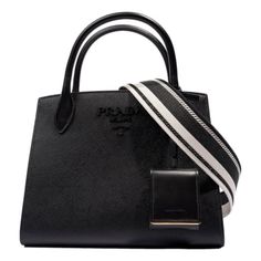 Introducing the epitome of sophistication and style, the Prada monochrome saffiano tote bag in timeless black exudes luxury and elegance. This exquisite piece showcases Prada's signature Saffiano leather, renowned for its durability and distinctive crosshatch texture. The double top handles offer a chic carry option, while the detachable woven crossbody strap provides added convenience and versatility. With ample interior space, this design features an interior zip and slip pocket. Finished with Black Saffiano Leather Shoulder Bag With Top Carry Handle, Black Saffiano Leather Shoulder Bag With Detachable Handle, Black Saffiano Leather Bag With Double Handle, Modern Black Saffiano Leather Bag, Elegant Black Saffiano Leather Shoulder Bag, Black Saffiano Leather Shopping Bags, Chic Black Saffiano Leather Bags, Black Luxury Saffiano Leather Shoulder Bag, Modern Saffiano Leather Shoulder Bag With Dust Bag