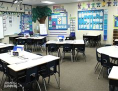 an empty classroom with desks and laptops on the tables in front of them