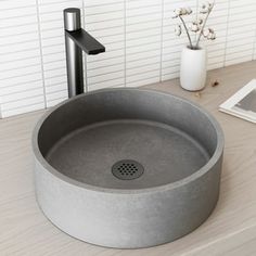 a round sink sitting on top of a wooden counter