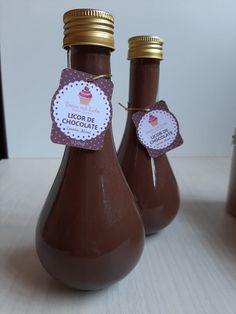 two chocolate bottles with labels on them sitting on a table