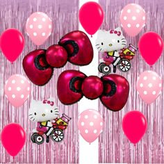 hello kitty balloons are flying in the air with pink and red streamers behind them