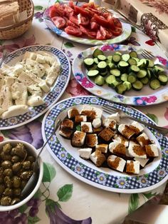 a table topped with plates of food and bowls filled with different types of vegetables next to each other