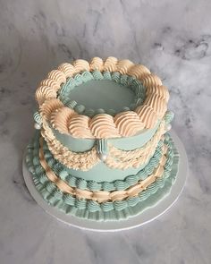 a three tiered cake sitting on top of a marble counter