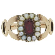 Here we have a charming cluster ring originally dating back to the Georgian period. A single elongated oval faceted ruby possessing a rich red colour tone sits at the centre of the face. This principal stone is then framed by a single row of round shaped pearls around the outer edge. A trio of graduating openings make up the shoulders and lead towards the face before the piece is finished with a roped style shank.  Condition: Used (Good) Weight: 2.7 grams Size: P (56.5) Face Dimensions: 11mm x 8mm Ruby Weight: Approx. 0.40ct Pearl Dimensions: 13 (1.5mm) Tested As: 9ct Gold Period: Georgian Box: The Vintage Jeweller Box Comments: As this is a antique ring, we have left the natural patina untreated. However, if preferred, this piece can be professionally polished to appear brand new. Please Ruby And Pearl, Face Dimensions, Pearl Cluster Ring, Elongated Oval, Shiny Objects, Pearl Cluster, La Face, Red Colour, Antique Rings