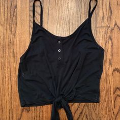 Black Tank Top With Buttons And A Tie At The Bottom. Tags On. Never Worn. Black Crop Top Tank Top For Beach, Casual Black Crop Top For Night Out, Black Cropped Tank Top For Spring, Urban Outfitters Sleeveless Black Crop Top, Urban Outfitters Black Casual Tops, Black Crop Top For Day Out, Black Cropped Tops By Urban Outfitters, Black Cropped Top From Urban Outfitters, Urban Outfitters Black Crop Top For Summer