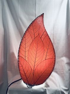 an orange leaf shaped lamp on a white background