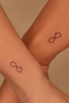 two people with matching tattoos on their legs, one is holding the other's hand