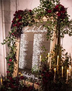 a table with candles and flowers on it next to a sign that says wedding seating