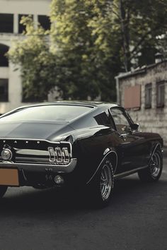 an old black car parked on the street