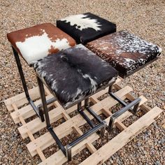 three stools made out of wooden pallets with cowhide and leather on them