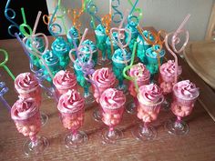 there are many cupcakes on the table with candy sticks in them and decorations