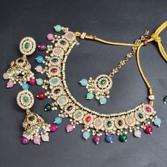 Adorn yourself in timeless elegance with our Multi Color Indian Bollywood Jewelry Set. This exquisite bridal choker necklace, accompanied by delicate earrings and an enchanting tikka, captures the essence of sophistication. Crafted with meticulous attention to detail, the luminous white pearls radiate a sense of purity and grace, making this set a perfect choice for weddings, anniversaries, engagements, and other special occasions. Inspired by the opulence of Bollywood aesthetics, this jewelry s Multicolor Kundan Choker Necklace For Wedding, Bohemian Bridal Choker Necklace For Wedding, Bohemian Jewelry Sets With Matching Earrings For Wedding, Multicolor Chandbali Jewelry For Wedding, Bohemian Necklace With Matching Earrings For Wedding, Bohemian Chandbali Necklaces For Wedding, Traditional Bridal Necklace With Matching Earrings For Party, Bohemian Wedding Necklace With Matching Earrings, Multicolor Tilla Jewelry For Wedding