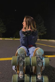 a woman sitting on top of a skateboard in the street