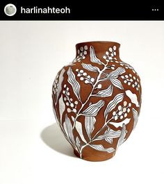 a brown and white vase sitting on top of a table