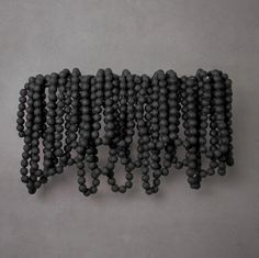 a group of black beads hanging from the side of a wall