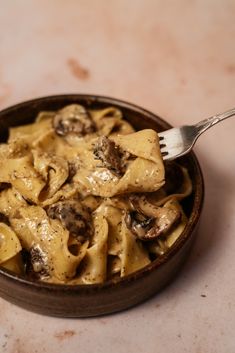 a bowl filled with pasta and mushrooms on top of a table