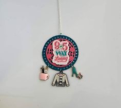 a necklace with an image of a woman's jacket and shoes hanging from it