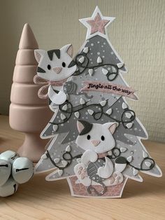 a christmas tree with two cats on it next to an egg holder and some eggs