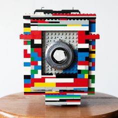 a camera made out of legos sitting on top of a wooden table