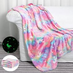 a blanket that is sitting on top of a white couch next to a green light