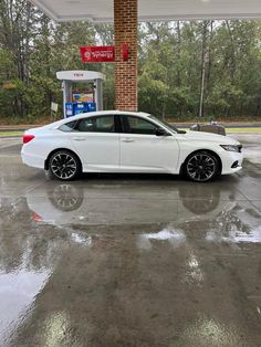 a white car is parked at a gas station