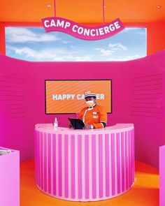 a man sitting at a desk in front of a sign that says happy camp concrege