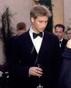 a man in a tuxedo standing next to a woman wearing a black dress