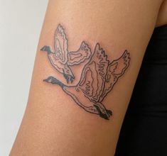 a woman's arm with a tattoo of two birds on it