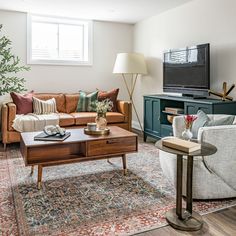 a living room filled with furniture and a flat screen tv on top of a wooden table