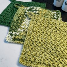 three crocheted placemats sitting on top of a table next to coffee cups