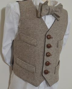 "This fine quality wool tweed vest is available in all sizes from toddler to youth.  It is made of 100% wool brown and ivory striped twill, and lined in dark brown 100% cotton.  It is designed as a  historical period style vest, with 5 natural leather buttons, 4 front welts, bottom pockets are functinal. Dry Clean Only. We now offer this very popular vest in black/ecru striped twill as well. Each vest is custom made to order, tailored to fit using customer supplied measurements, and muslin fitti