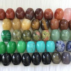 a group of different colored stones sitting on top of a white table next to each other