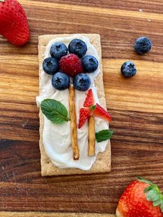 some strawberries and blueberries are on top of a cracker