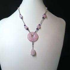 On offer is this elegant Vintage Chinese Necklace featuring a Central Round Translucent Pink Rose Quartz Circle suspended from an ornate Snail design sterling silver chain. There are hand carved Lotus design Pink Rose Quartz beads with smaller round Amethyst gems and smaller round Rose Quartz gems with a spring clasp that opens and closes tightly. There is dangling Rose Quartz Pendant that is carved into the shape of a little Monkey. The necklace measures 17 inches in length. The gems are highly Chinese Necklace, Chinese Art Deco, Lotus Design, Rose Quartz Pendant, Amethyst Gem, Rose Quartz Beads, Little Monkeys, Quartz Beads, Amethyst Beads