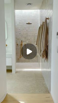 a walk in shower sitting next to a white wall and wooden floored bathroom area