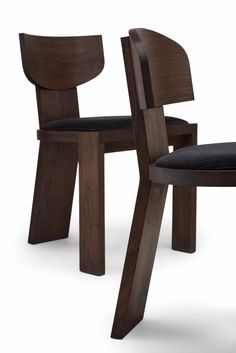 two wooden chairs sitting next to each other