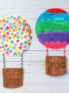 two paper plates with flowers on them are next to each other and one is made out of popsicle sticks