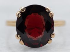 This beautiful yellow gold solitaire ring showcases a single garnet gemstone. Its timeless design and quality craftsmanship lasts for generations, providing you with a timeless piece of jewelry for decades to come. Metal: 18K Yellow Gold Gem: Garnet 5.11 Carats Gem Measurements: 9.9 x 11.3 mm, Oval Ring Size: 6.50 SKU #: A28605 Each piece has been identified and graded by a Graduate Gemologist who has been certified by the Gemological Institute of America (GIA). We have six brick-and-mortar storefronts in Maine, Massachusetts, and New Hampshire and have been in business for over 25 years! Please visit our Shop's About Page or our website for more information about our jewelry. For questions about diamond grading, we recommend the  Gemological Institute of America (GIA), the founders of the Classic Garnet Round Cut Ring, Classic Garnet Rings With Round Cut, Classic Garnet Ring With Round Cut, Formal Garnet Birthstone Ring In Fine Jewelry Style, Classic Yellow Gold Garnet Birthstone Ring, Classic Garnet Birthstone Ring In Yellow Gold, Formal Garnet Birthstone Ring Fine Jewelry, Formal Garnet Birthstone Ring, Classic Yellow Gold Garnet Rings