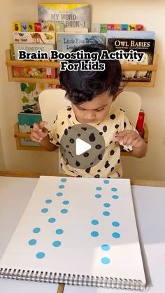 a little boy sitting at a table with a book on it and the words brain booster activity for kids