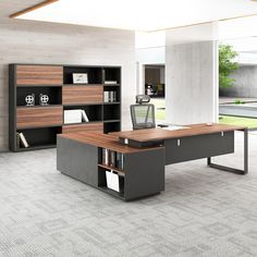 an office desk with bookshelves and cabinets in the middle of a large room