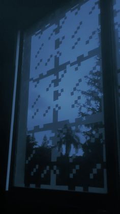 an image of a window that is outside in the dark with trees and clouds behind it