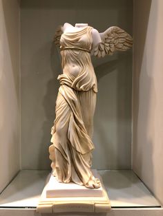 a statue of an angel with wings in a niche