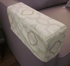 a close up of a couch with a pillow on top of it's back