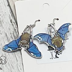 two earrings with blue and brown designs on them