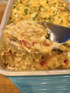 a spoon scooping some food out of a casserole dish