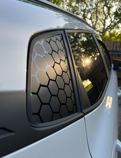 the side view mirror of a white car with hexagonal design on it's side