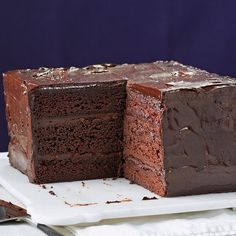 a piece of chocolate cake on a plate with a knife and fork next to it