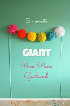 there is a sign that says giant pom garland on the wall